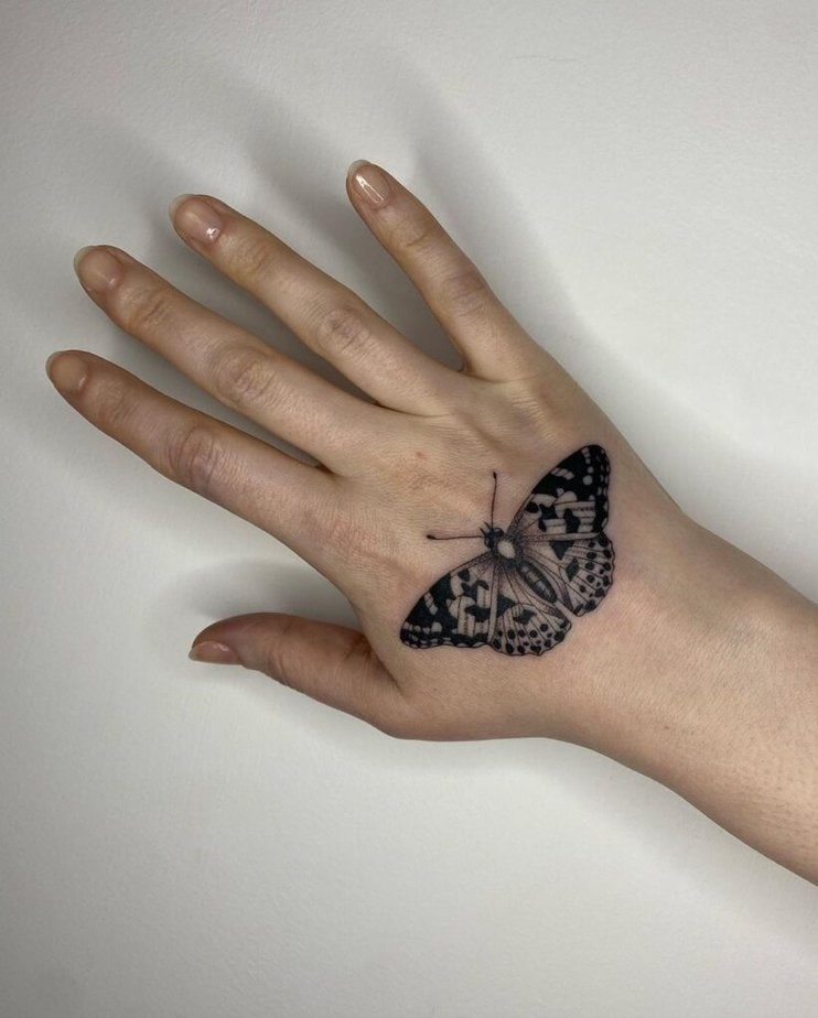 9. A statement butterfly hand tattoo 