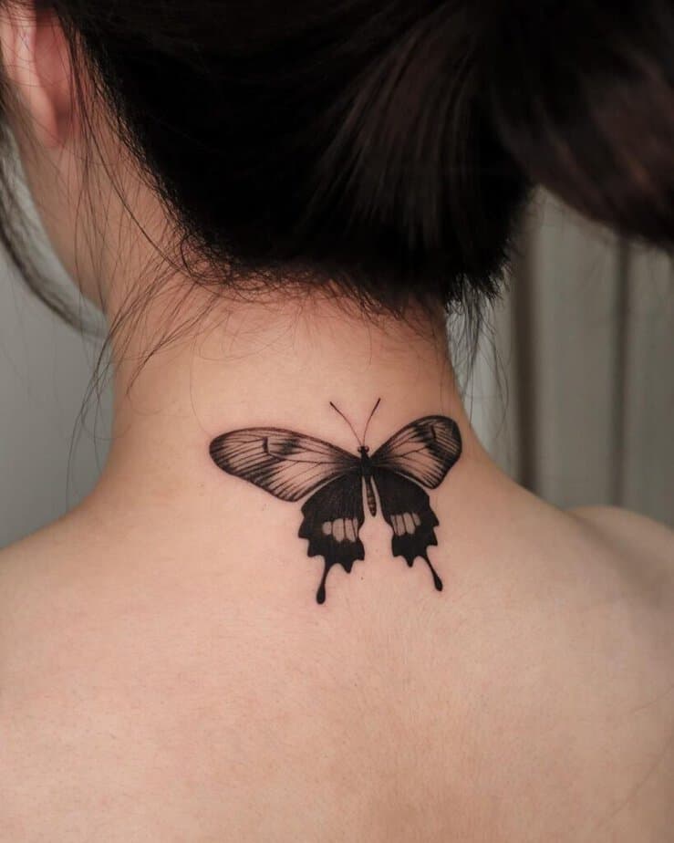 1. Un tatuaggio scuro e dettagliato sul collo a forma di farfalla 