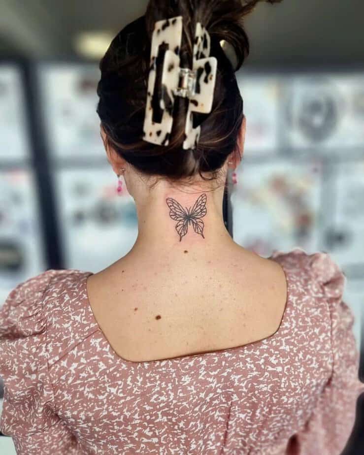 19. A fine-line butterfly tattoo on the back of the neck