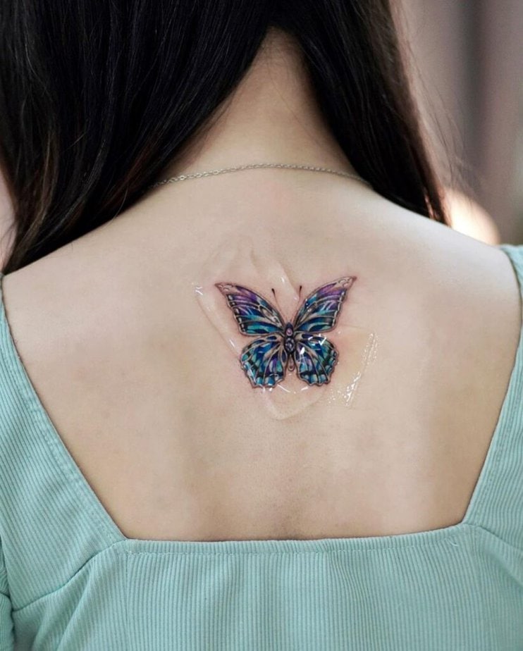 21. An iridescent butterfly neck tattoo 