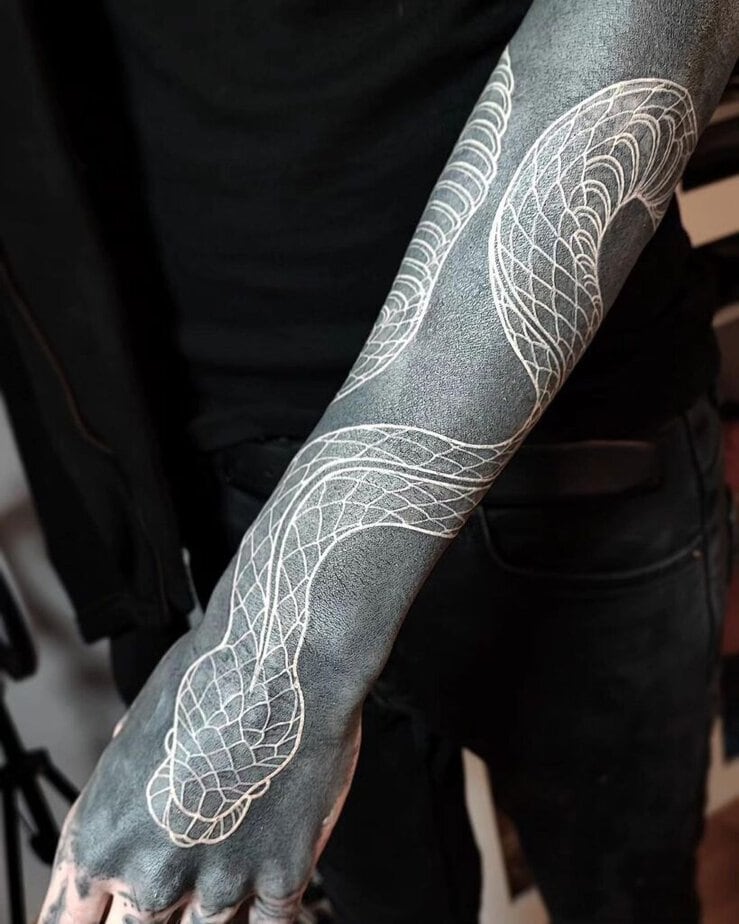 17. A black sleeve tattoo with a snake 