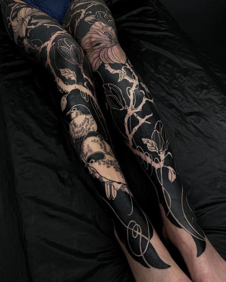 7. A black sleeve tattoo on both legs
