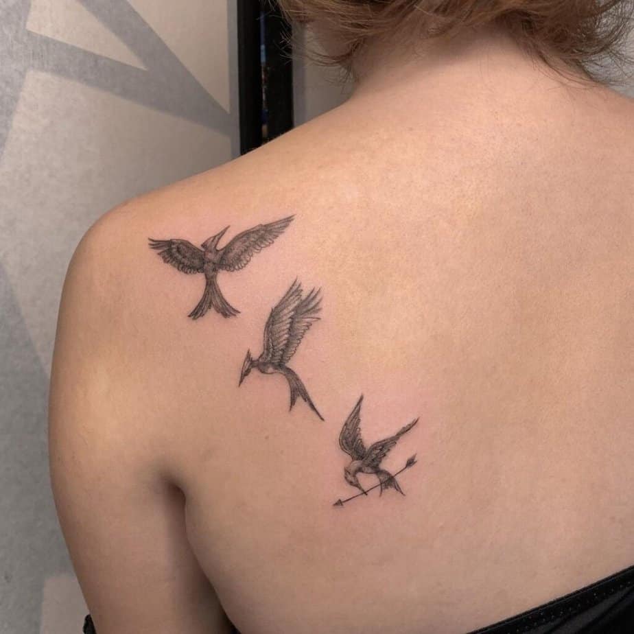 14. A Mockingjay tattoo on the back 