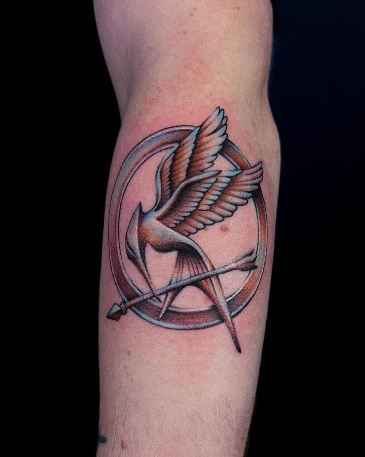4. Un tatuaggio cromato con il simbolo di Mockingjay 