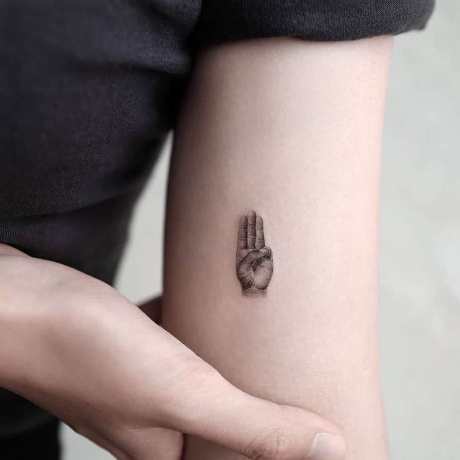 6. Un tatuaggio del saluto a tre dita 