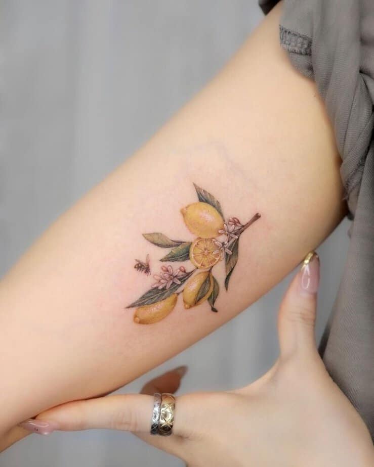 19. Un tatuaggio di un ramo di limone con un'ape