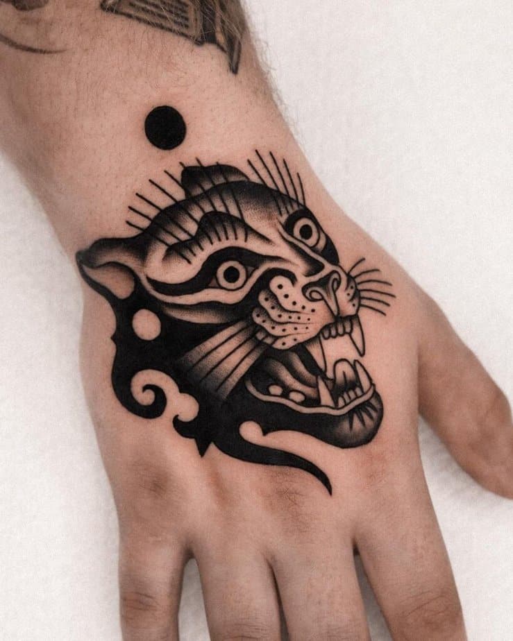 14. A black and gray panther tattoo on the wrist