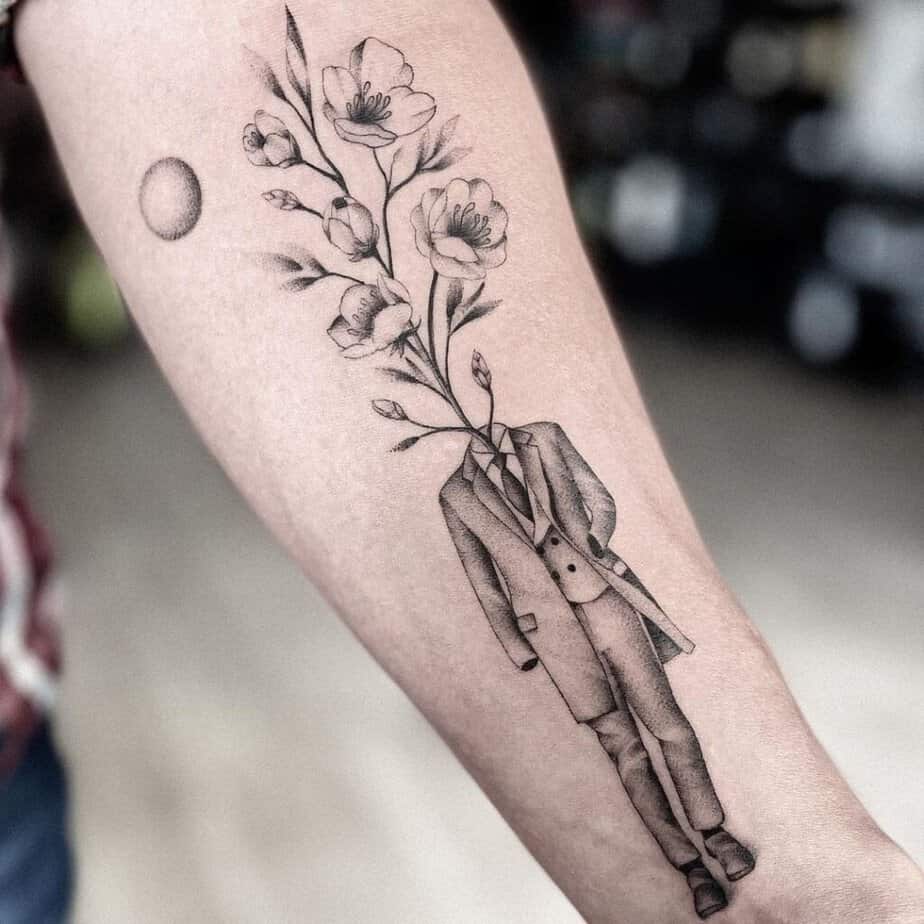 11. A surreal apple blossom tattoo coming out of a man’s body