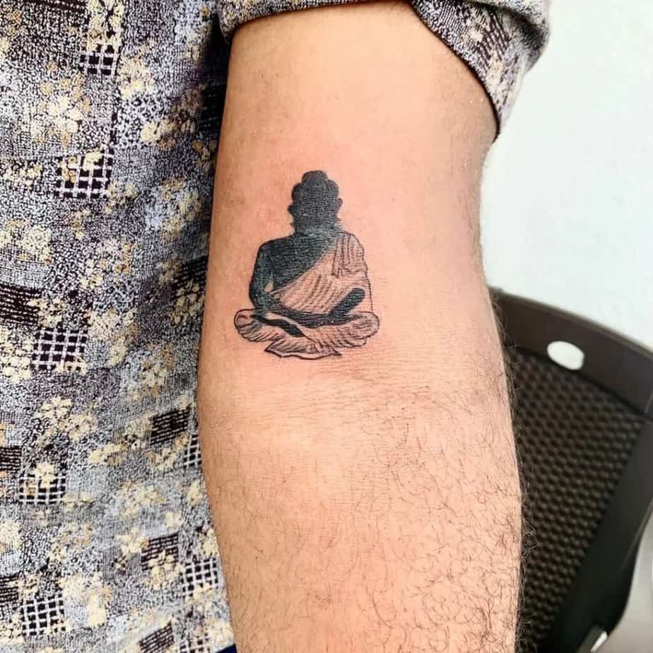 22. A tiny Buddha tattoo on the arm