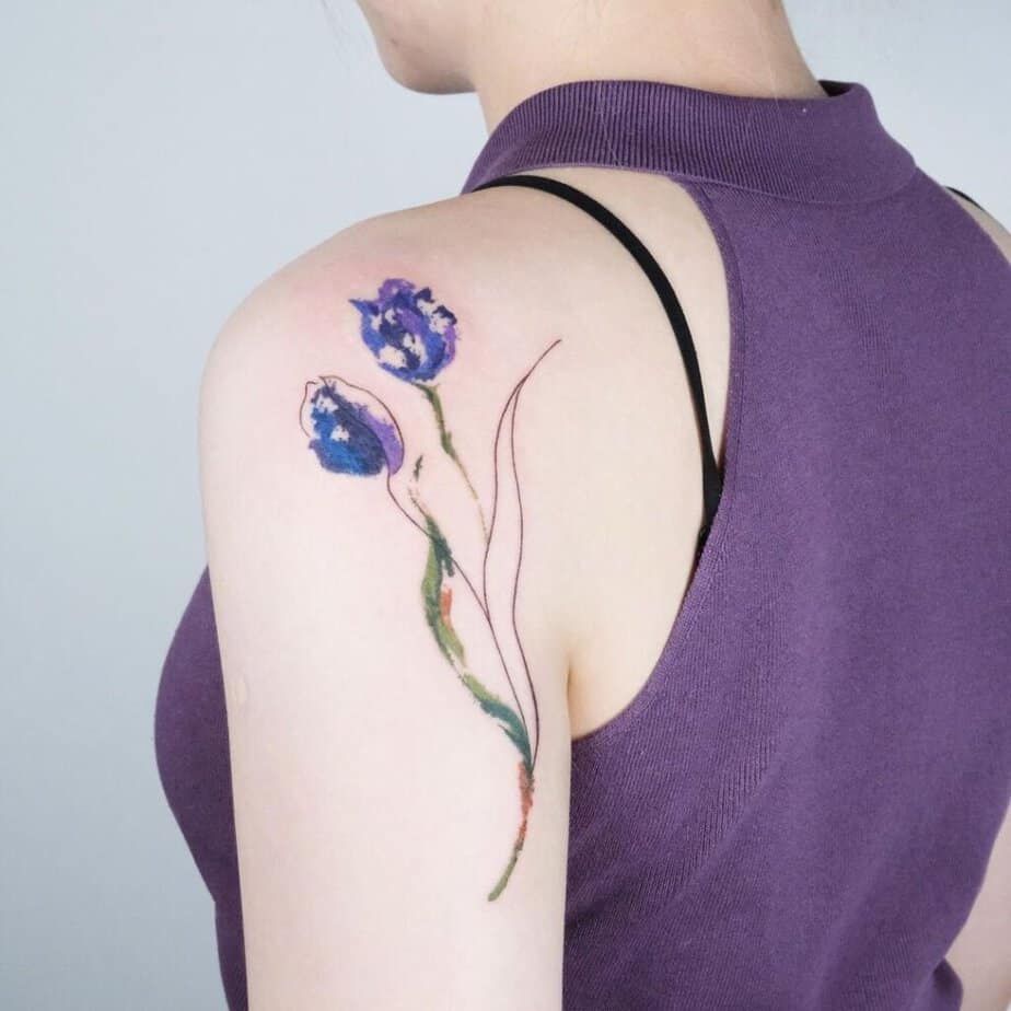11. A watercolor tattoo of two tulips on the back of the shoulder 
