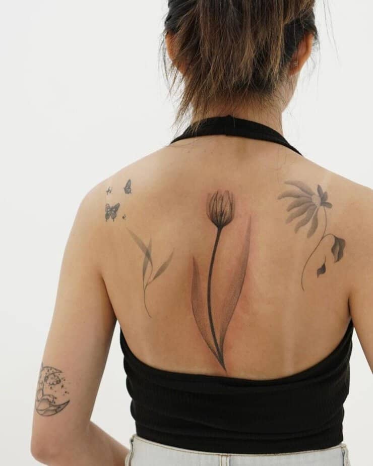 13. Un tatuaggio sulla spina dorsale raffigurante un tulipano