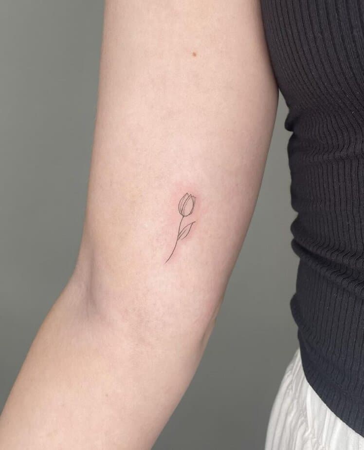21. A minimalist tulip tattoo on the bicep