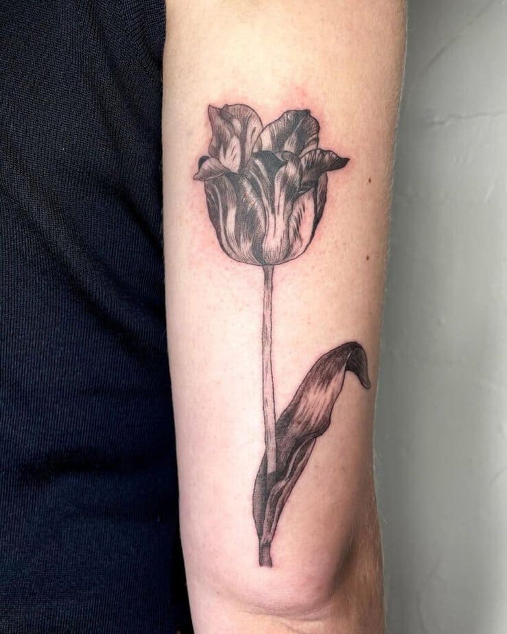 7. A tulip tattoo on the back of the arm