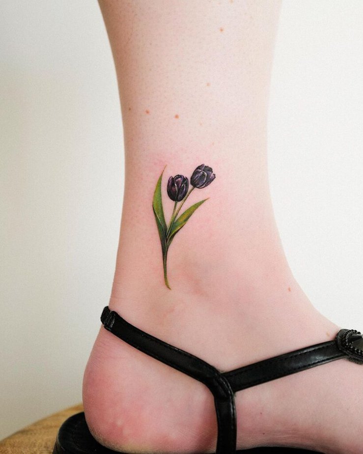 9. A tiny ankle tattoo of two black tulips 