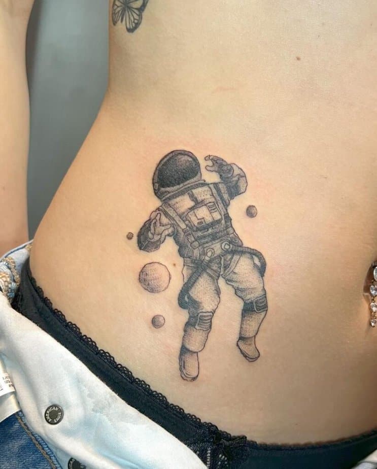 Tatuaggi di astronauti che si appoggiano sullo stomaco