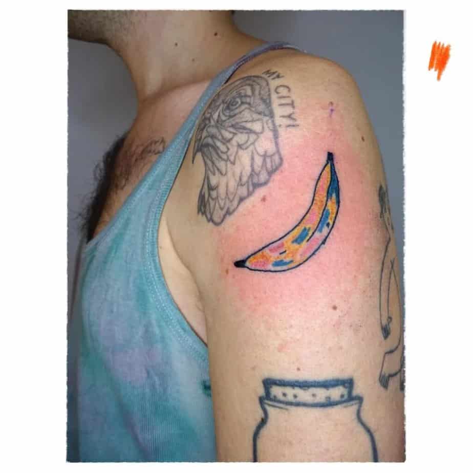 7. A colorful banana tattoo on the upper arm