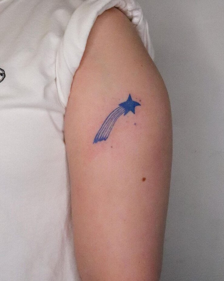 19. A blue ink shooting star tattoo