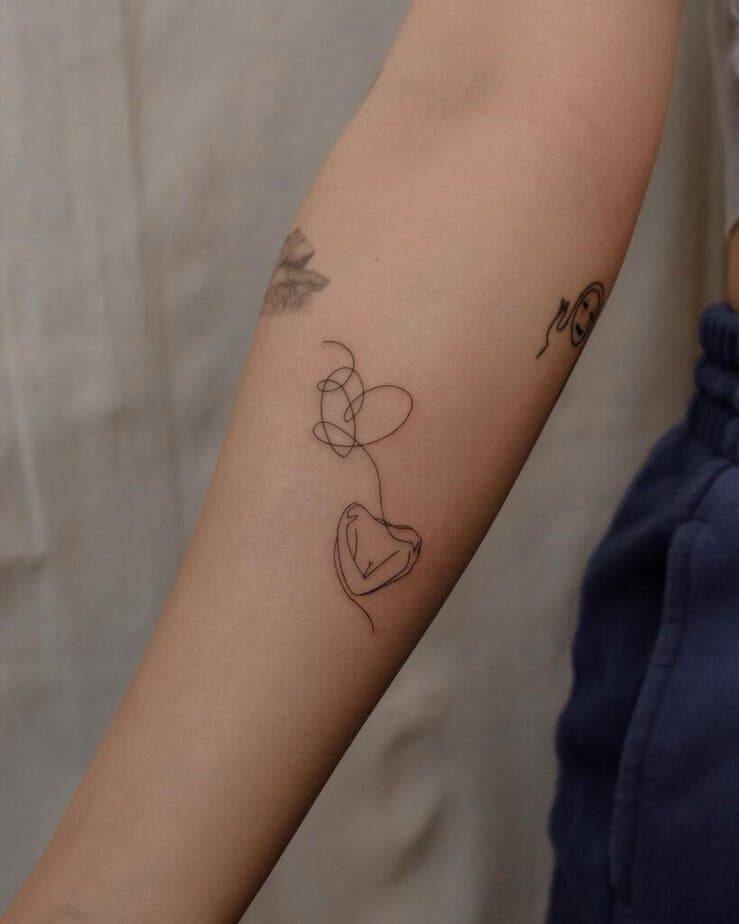 11. A linework heart hand tattoo