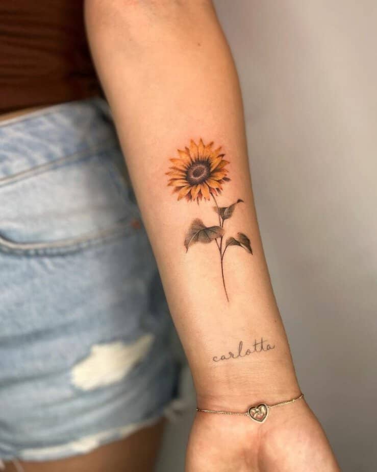 22. A sunflower tattoo with a word, a mantra, or a name 