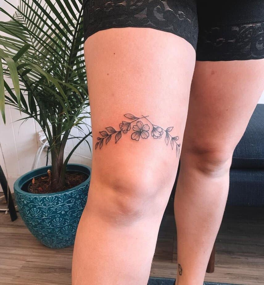 Tatuaggio floreale sopra il ginocchio