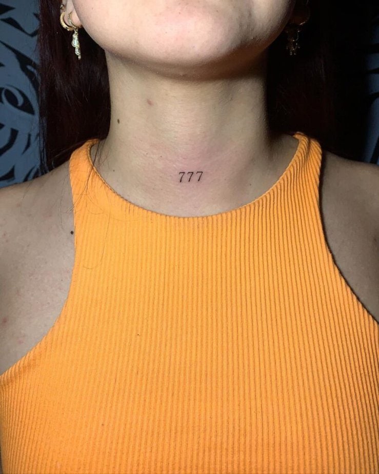 12. A tattoo of angel number 777 on the front of the neck