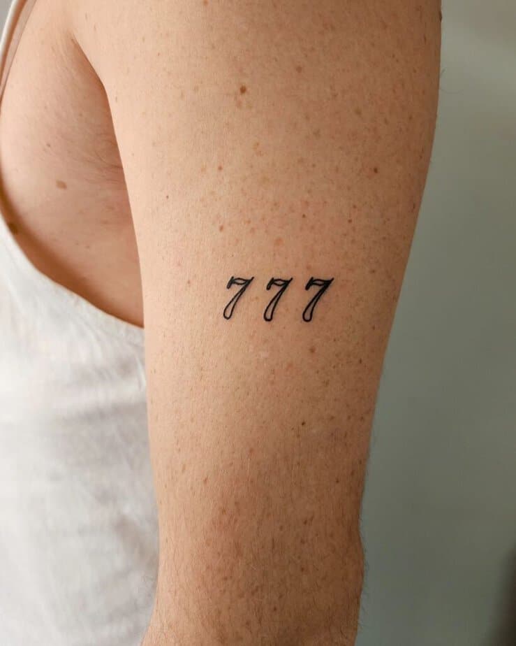 16. A tattoo of angel number 777 on the upper arm