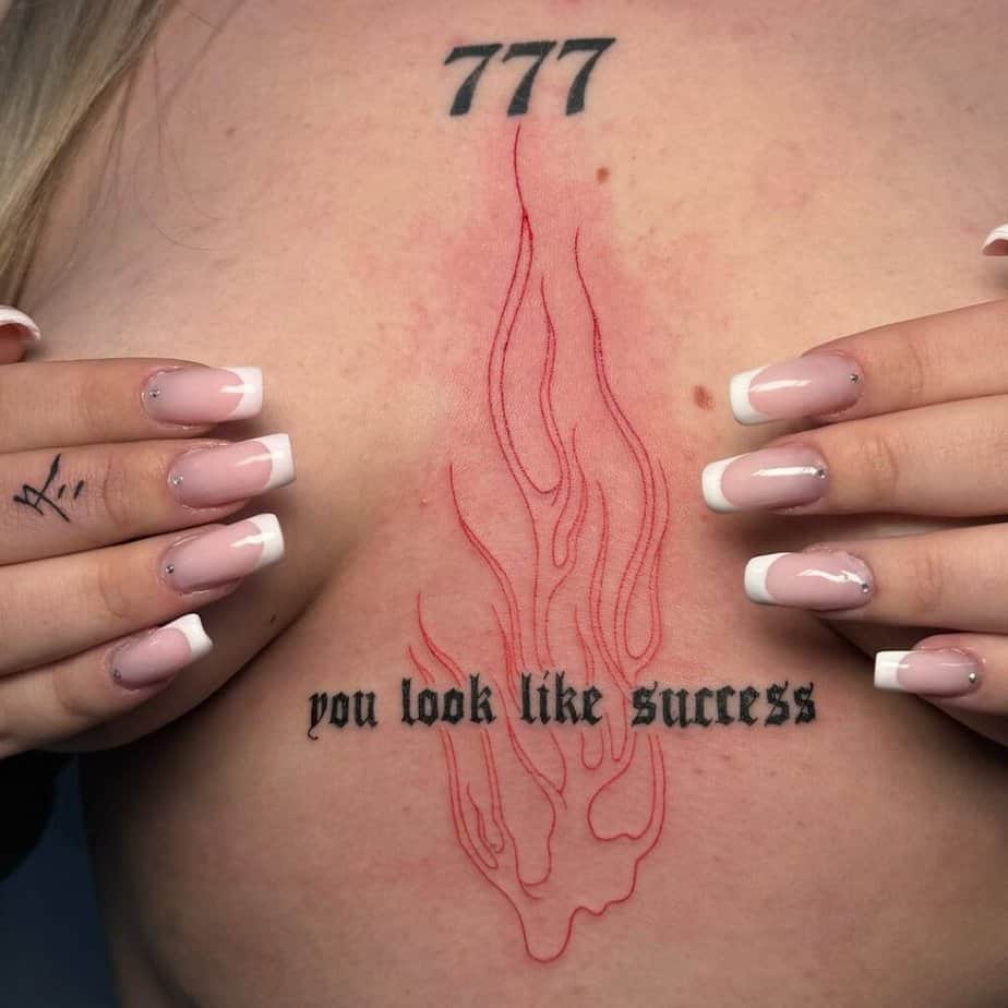 9. A tattoo of angel number 777 with flames and words