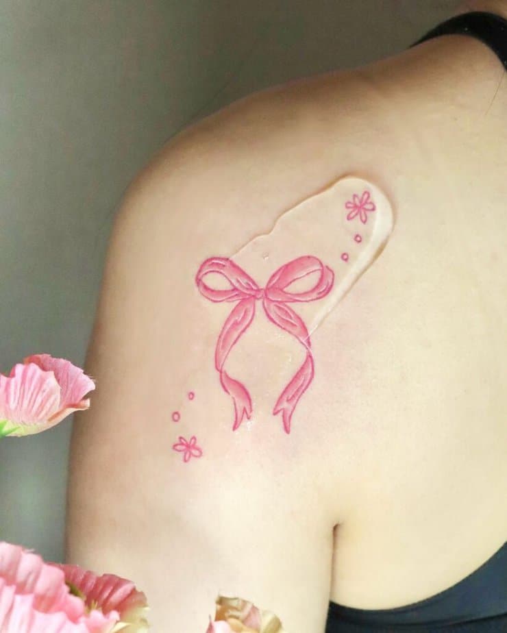 19. Un tatuaggio di un nastro rosa con fiori 