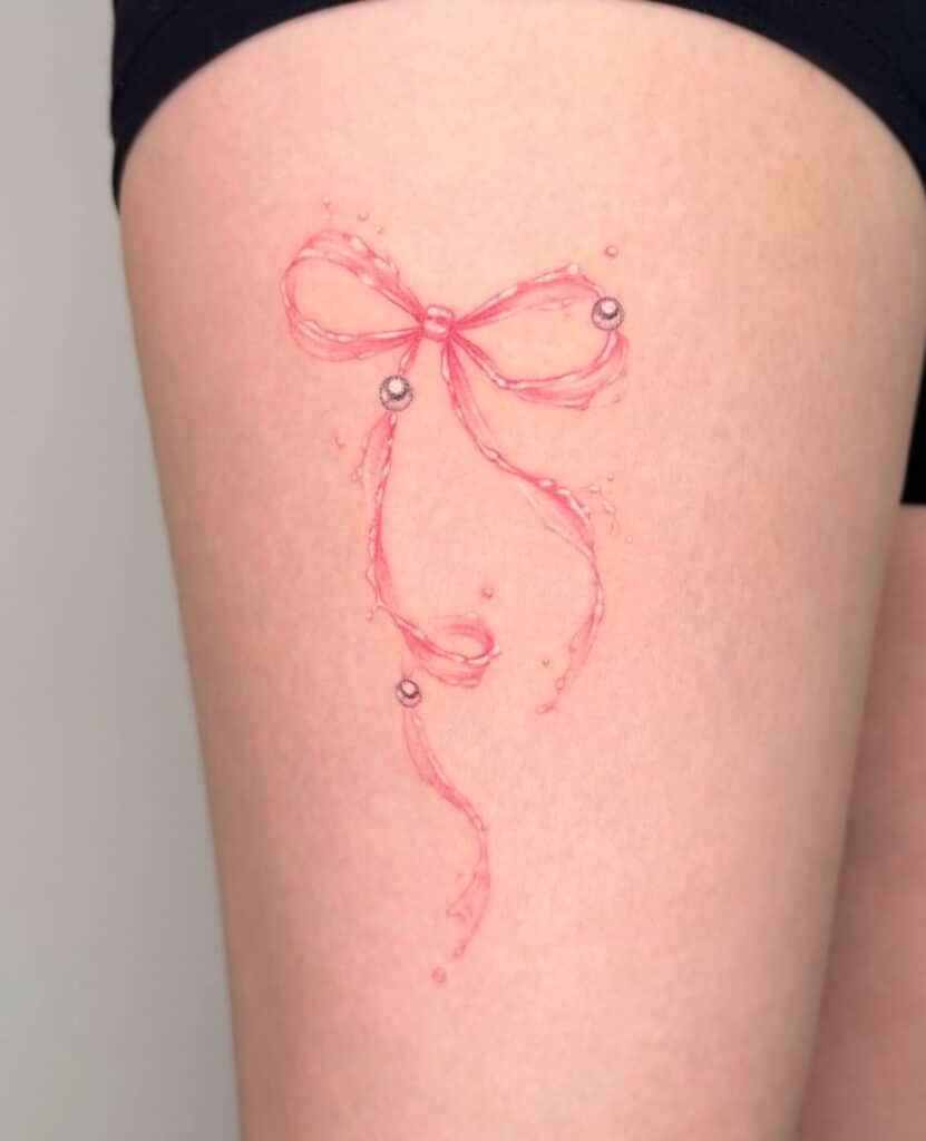 21. Un tatuaggio di un nastro rosa con perle 