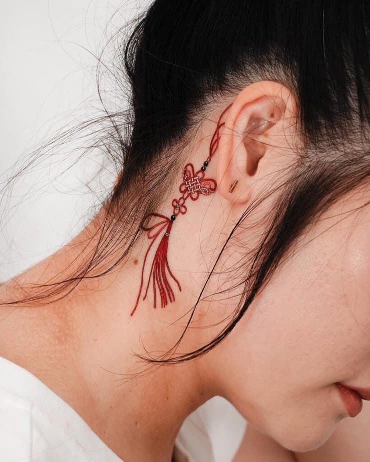 17. Un tatuaggio di nodi e nappe a farfalla 