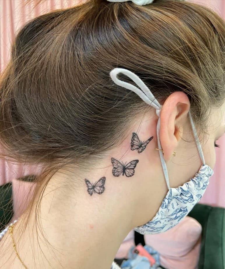 6. A tattoo of three butterflies behind the ear