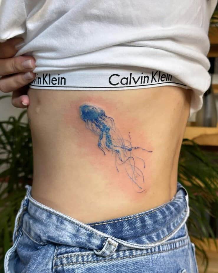 18. A blue jellyfish tattoo on the ribcage