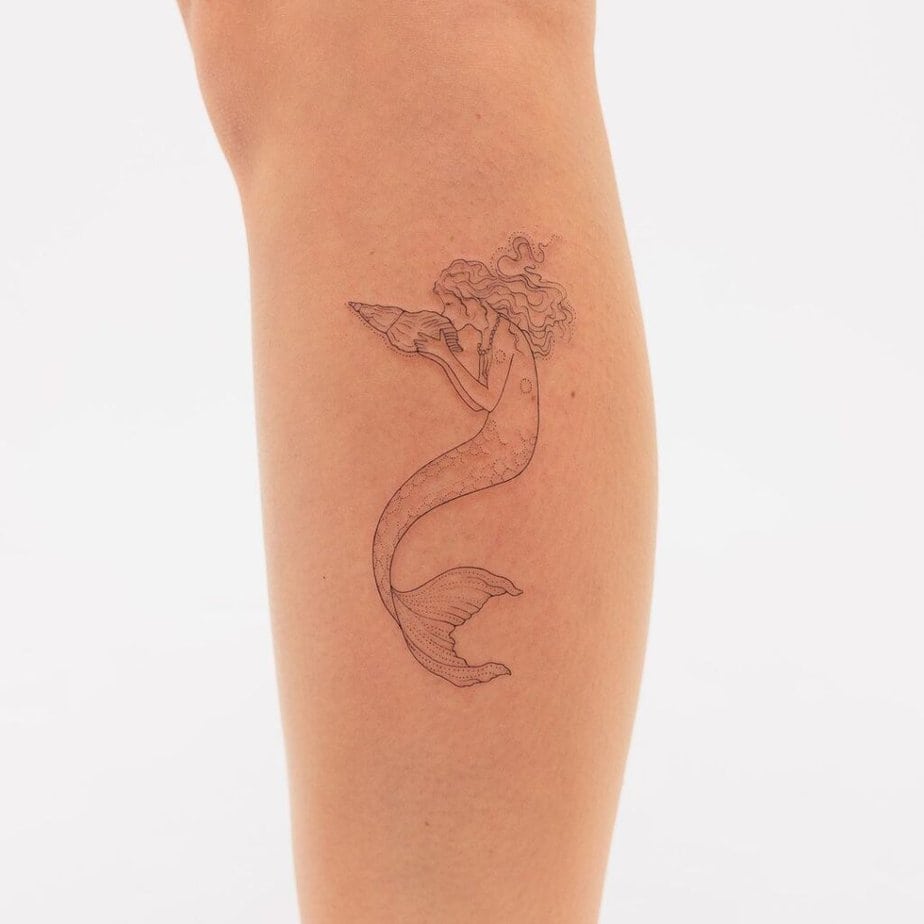 11. A tattoo of a mermaid kissing a seashell 