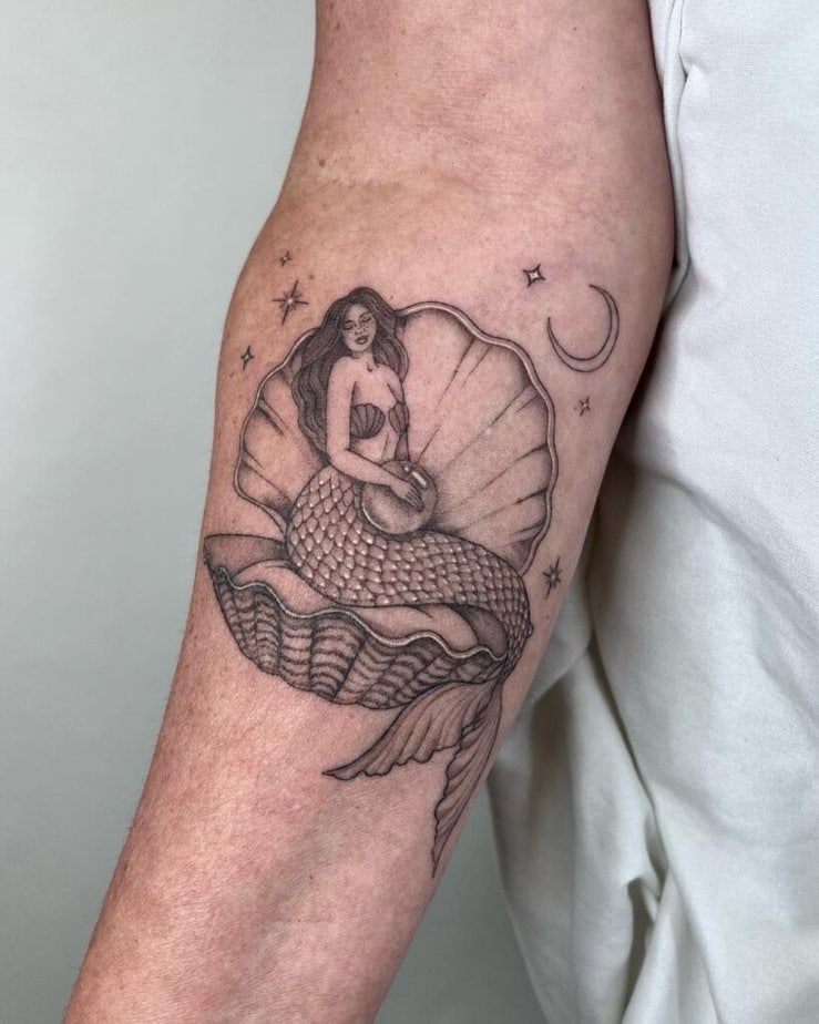 2. Tatuaggio di una sirena seduta su una conchiglia 