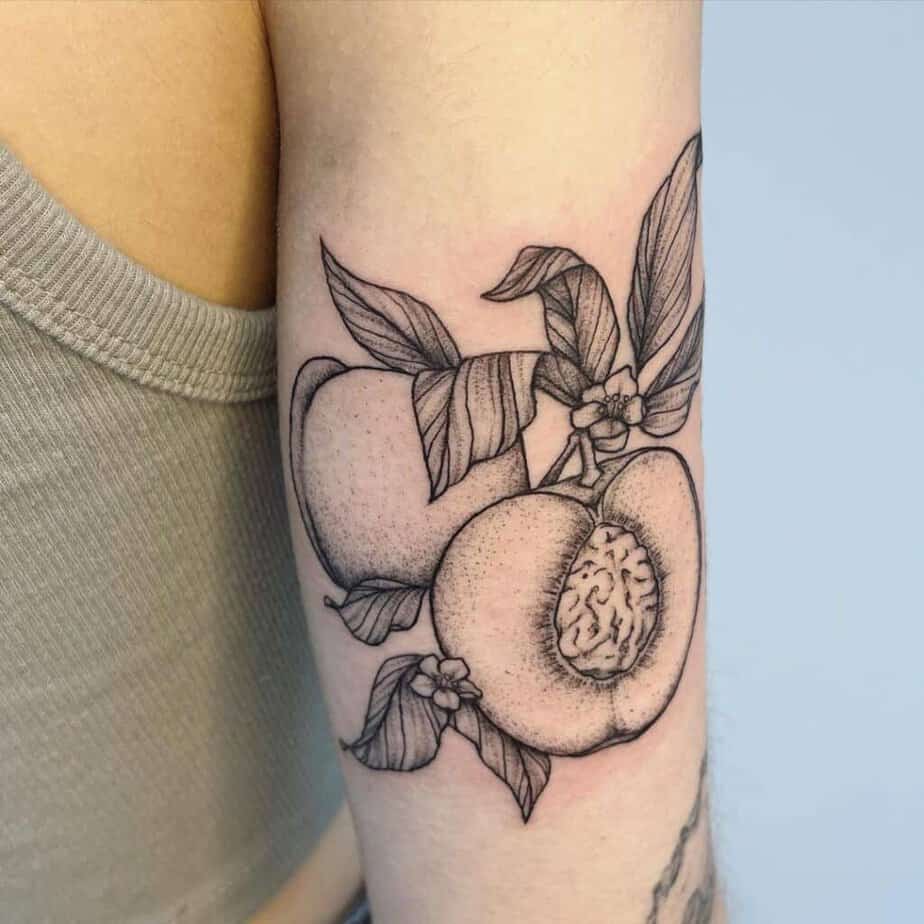 14. A peach tattoo on the back of the arm 