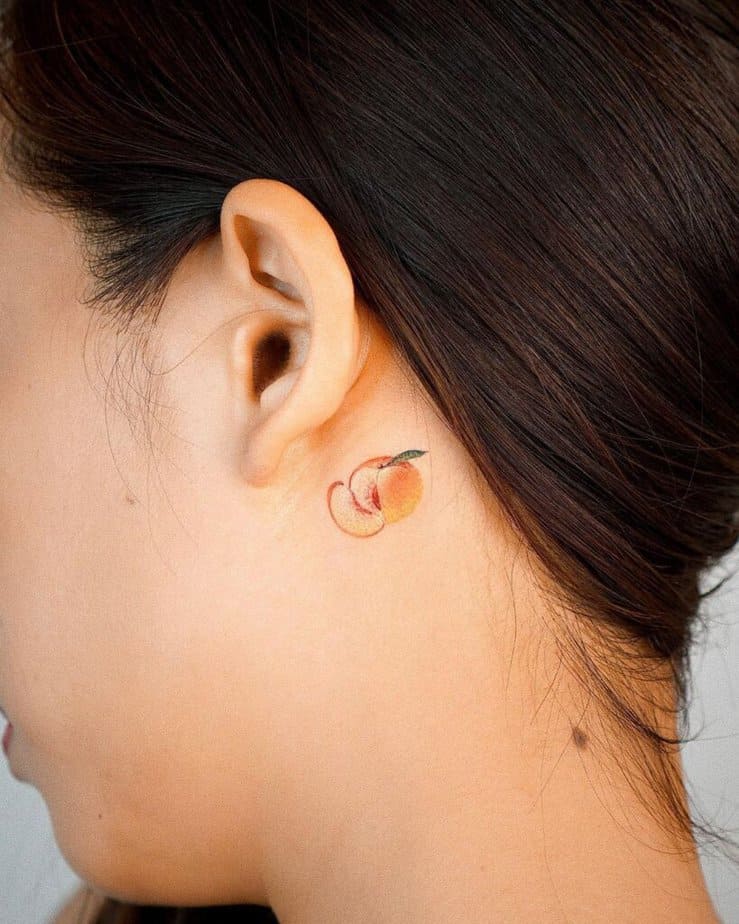 9. A behind-the-ear peach tattoo 