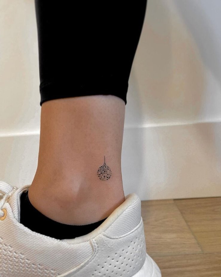 15. Un delicato tatuaggio alla caviglia a forma di palla da discoteca 