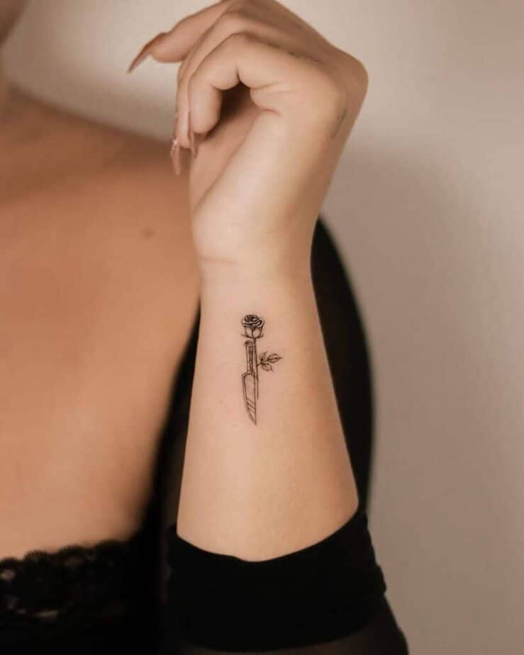 8. A tattoo of a rose and a knife 