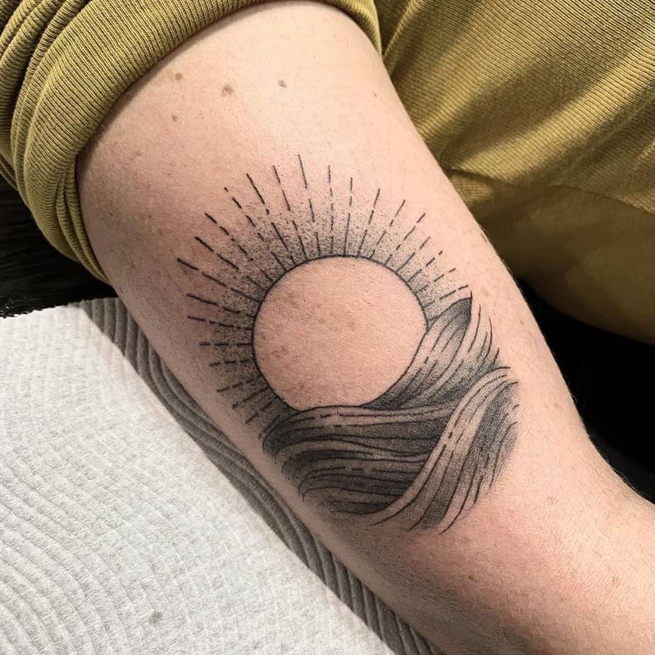 Wave and sun tattoo ideas done with black ink