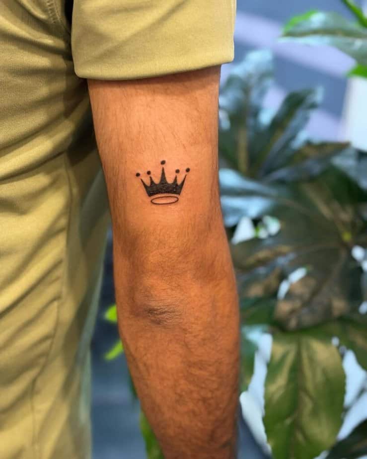 11. Un piccolo tatuaggio a forma di corona sul retro del braccio