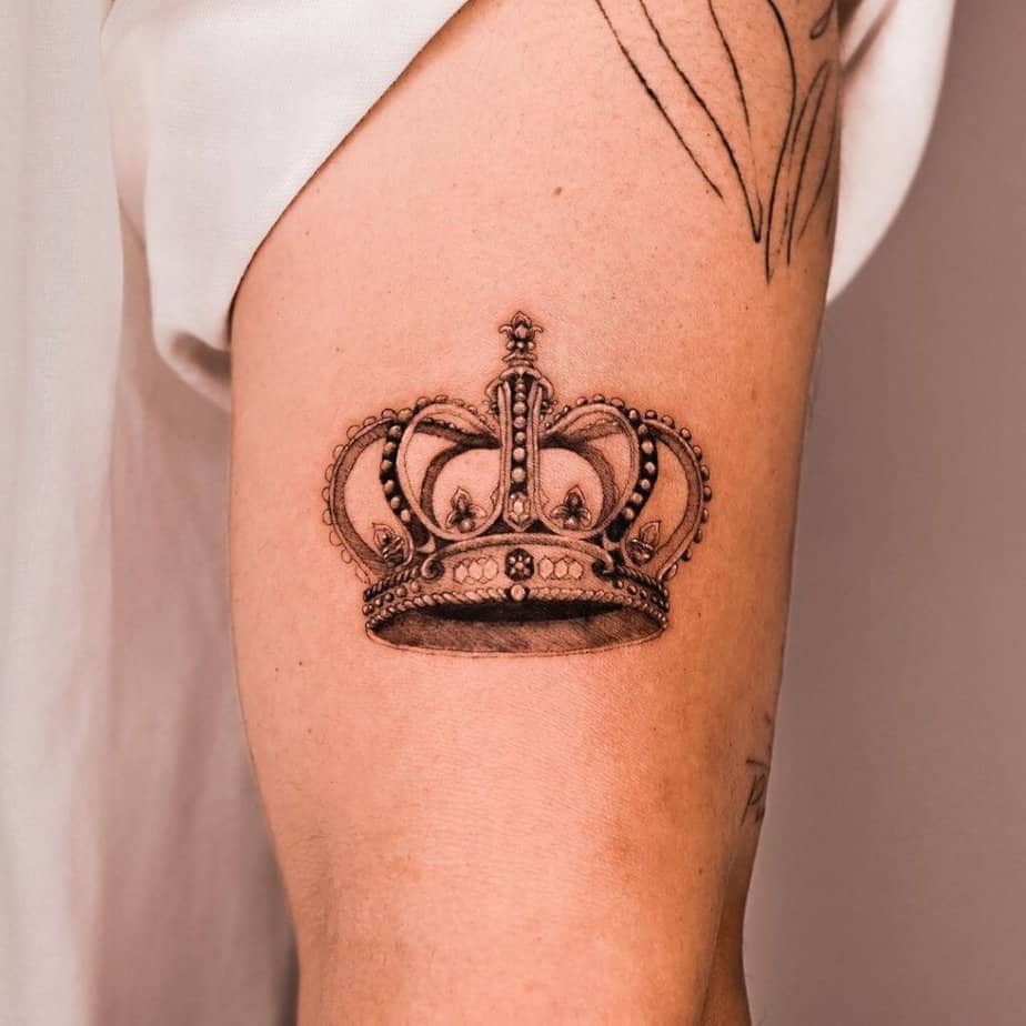 2. Un tatuaggio a corona dettagliato sulla parte superiore del braccio