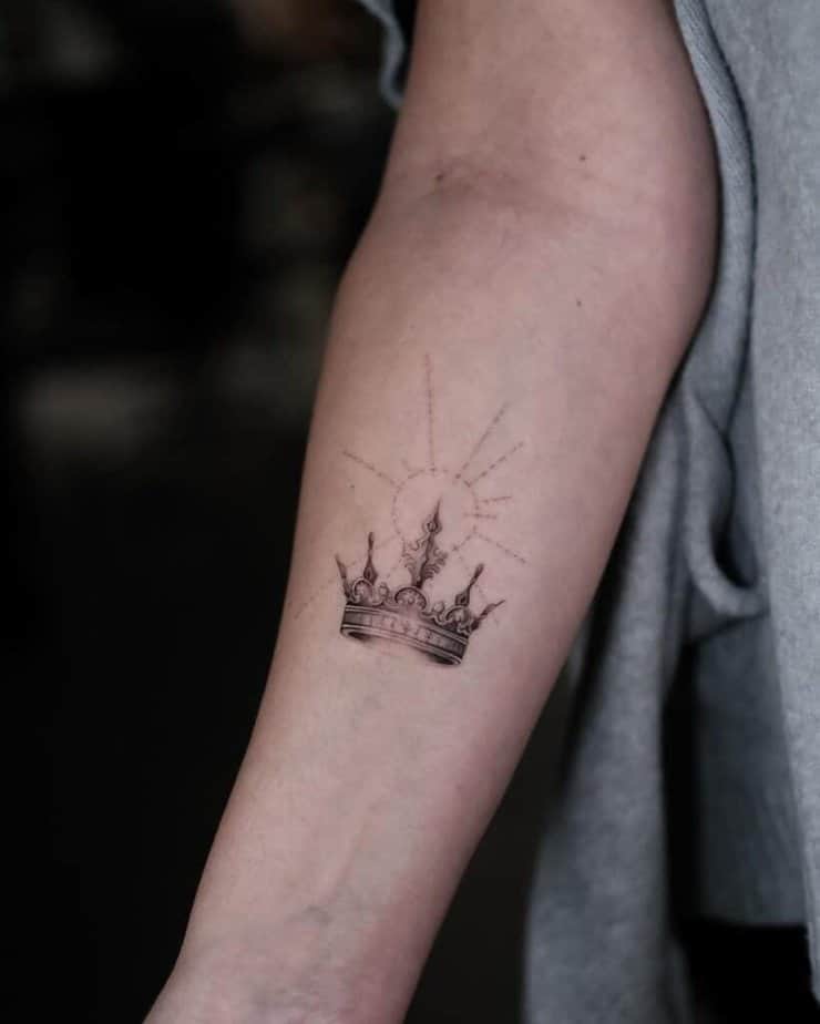 22. Un tatuaggio a corona dettagliato con un sole a punti