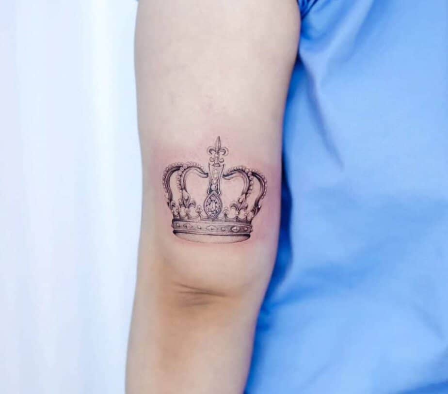 6. Un delicato tatuaggio a corona sul retro del braccio