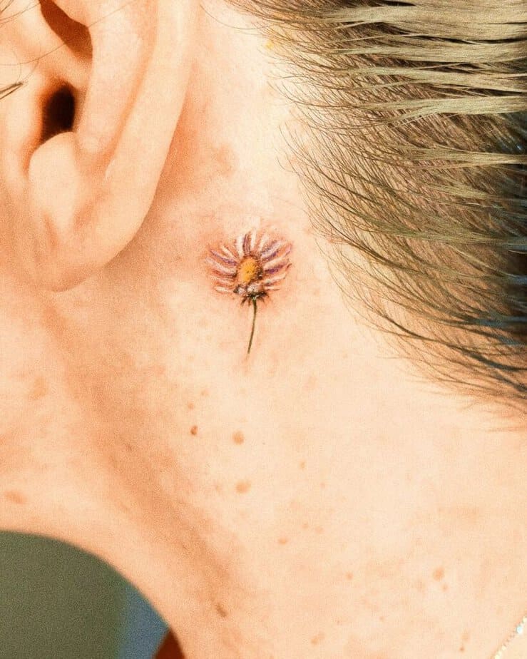 16. Tatuaggio di una margherita dietro l'orecchio 