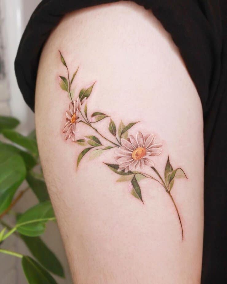 19. A daisy tattoo on the upper arm