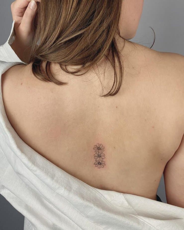 25. Tatuaggio di una margherita sulla schiena 