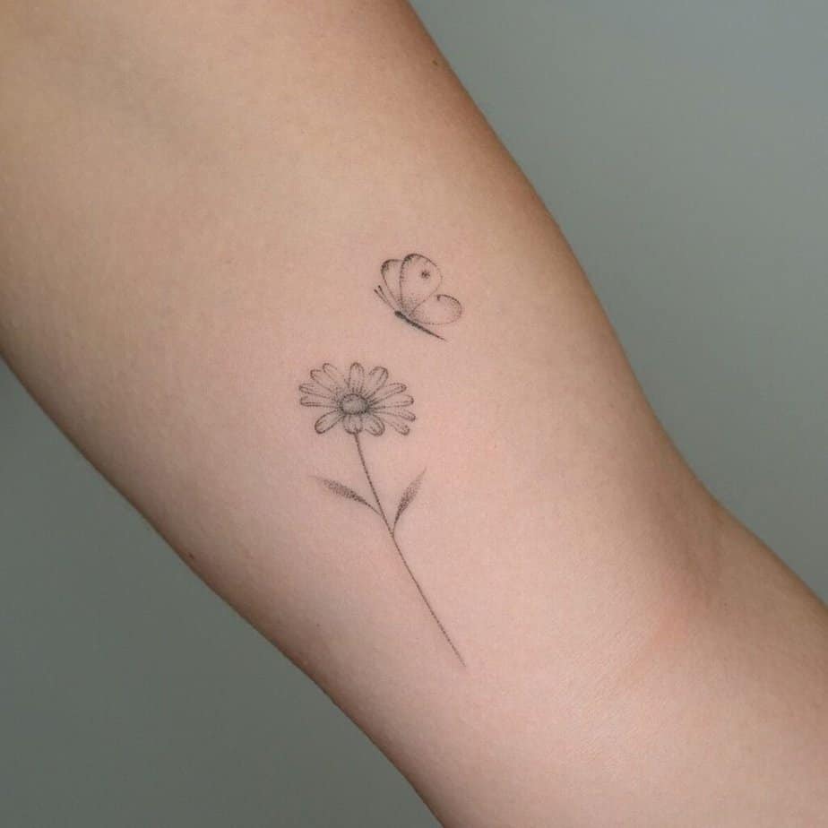 6. A tattoo of a daisy with a butterfly