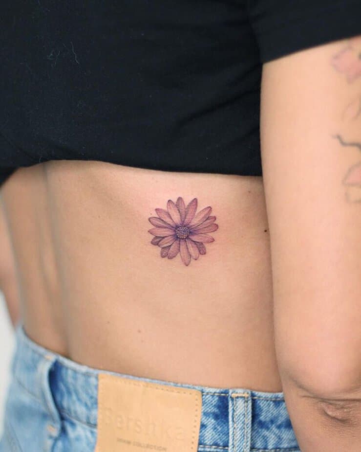 7. Un tatuaggio a forma di margherita sulla schiena