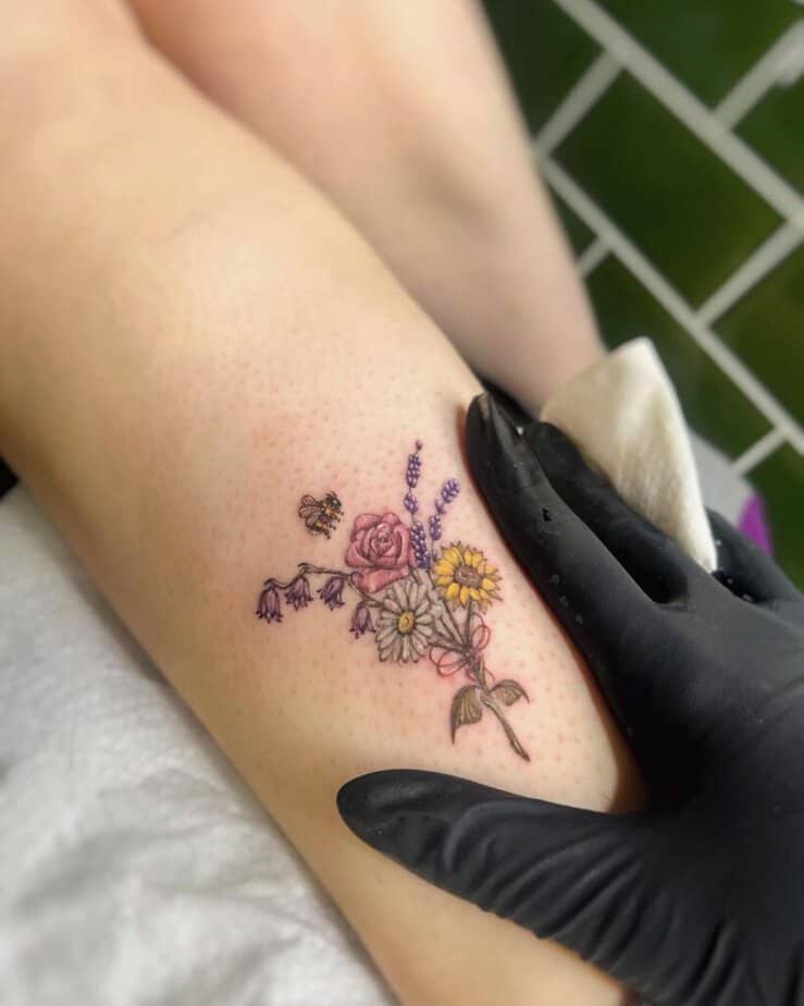 8. Un tatuaggio con un bouquet di margherite colorate 