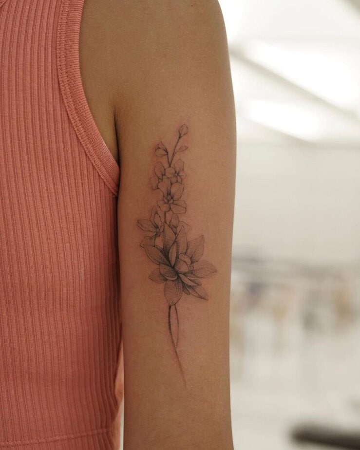 16. Tatuaggio con ninfea e delphinium sul retro del braccio